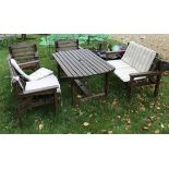 A pair of modern slatted wooden garden benches together with two matching garden chairs and similar