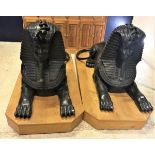 A pair of cast bronze sphinx figures of typical form raised on purpose built oak plinth bases