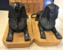 A pair of cast bronze sphinx figures of typical form raised on purpose built oak plinth bases
