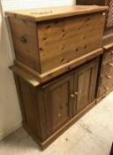 A modern pine trunk with oak leaf and acorn decoration and a pine two door kitchen cupboard and