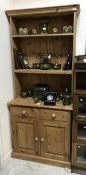 A modern pine dresser with three tier plate rack over two drawers and two cupboard doors
