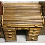 A modern teak tambour topped desk with fitted interior over a central kneehole and drawer flanked