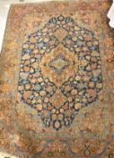 A Persian rug, the central panel set with all-over floral decoration on a blue and fawn ground,