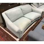 A Laura Ashley pale blue / green upholstered sofa of curved form with stained beech front legs to