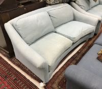 A Laura Ashley pale blue / green upholstered sofa of curved form with stained beech front legs to