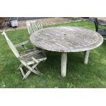 A modern teak slatted circular garden table on turned legs and two slatted elbow chairs