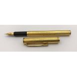 A yellow metal Dunhill fountain pen with engine turned decoration,