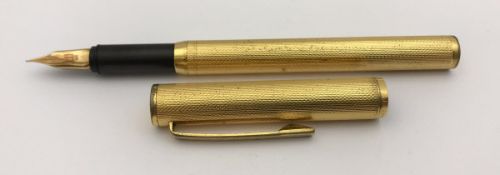 A yellow metal Dunhill fountain pen with engine turned decoration,