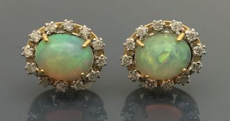 A pair of 18 carat gold opal and diamond set cluster earrings