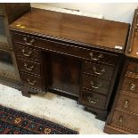 A mahogany kneehole desk in the George III manner,