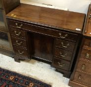 A mahogany kneehole desk in the George III manner,