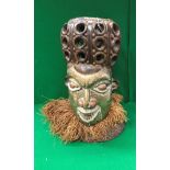 A 20th Century West African carved hardwood and brass and copper embellished helmet mask with grass