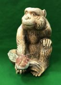 A Japanese Meiji period porcelain figure of a monkey with peach