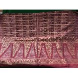 An early 20th Century Indian deep red silk table cover decorated in gold and silver wire with