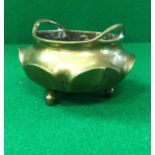 A Chinese bronze censer of small proportions with lotus leaf design raised on three plain feet