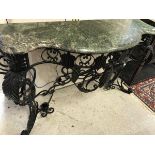 A wrought iron console table in the Rococo style black painted with green marble top