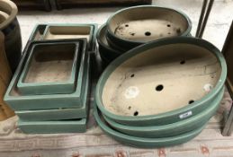 A collection of fourteen Japanese green glazed Bonsai pots of varying sizes - seven oval and seven