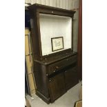 A late Victorian oak bookcase cabinet with open shelving over a secretaire drawer and two cupboard