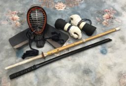 A late 20th Century kendo mask and pair of gloves and two practice shinai