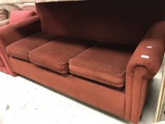 A modern red upholstered scroll arm three seat sofa bed