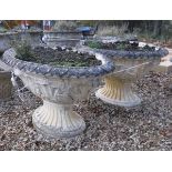 A pair of 19th Century style reconstituted stone oval planters with foliate decorated rims and main