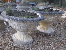 A pair of 19th Century style reconstituted stone oval planters with foliate decorated rims and main