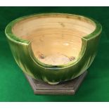 A circa 1900 Japanese oribe ceramic furo with green and yellow glazes on wooden plinth base