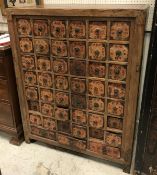 An Oriental elm chest of forty-five drawers each with script embellished paper labels and ring