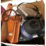 A Fuji Instax instant camera and two film packs, a Polaroid 103 instant land camera,