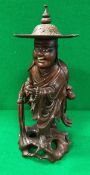 An early 20th Century Chinese carved wooden figure of a lohan with ivory teeth and eyes