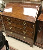 A George III mahogany bureau with sloping fall above four long graduated drawers to bracket feet