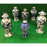 A pair of 19th Century Chinese blue and white baluster shaped vases and covers decorated with four