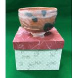 A modern Japanese raku yaki aka raku chawan with orange and black glazed decoration,