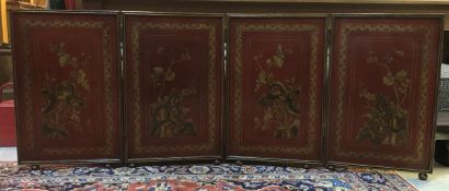 A circa 1900 red lacquered and gilt decorated Chinese four fold screen each panel decorated with