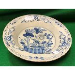 An 18th Century Delft bowl decorated in the chinoiserie style with garden flowers and tree