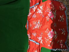 A Chinese red silk jacket with all over decoration of floral sprays and insects