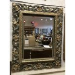A 19th Century giltwood framed mirror with carved scroll and foliate frame and bevelled plate