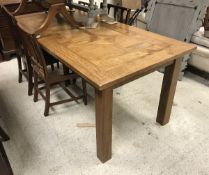 A modern rectangular extending farmhouse style dining table with two leaves, on square supports,