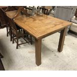 A modern rectangular extending farmhouse style dining table with two leaves, on square supports,