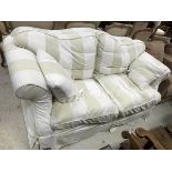 A modern upholstered scroll arm sofa with striped upholstery