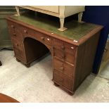 A mahogany kneehole desk with tooled and gilded leather insert top over three frieze drawers on two