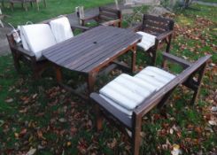 A pair of modern slatted wooden garden benches together with two matching garden chairs and similar