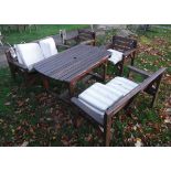 A pair of modern slatted wooden garden benches together with two matching garden chairs and similar