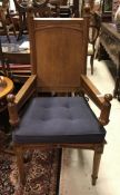 A Victorian oak panel seated hall chair in the Pugin manner the arms with part supports