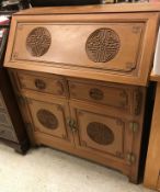 A modern Chinese teak bureau, the sloping fall over two drawers and two cupboard doors,