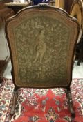 An early 20th Century walnut framed fire screen in the Louis XV taste with gros and petit point
