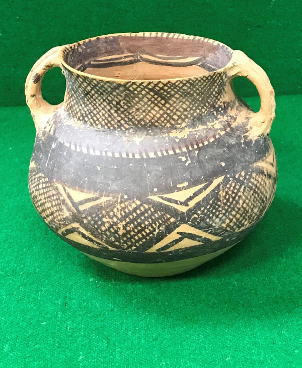 A Chinese Neolithic period terracotta vessel with open work handles and lozenge medallion hatched