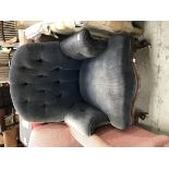 A Victorian buttoned upholstered scroll armchair on carved cabriole front legs to scroll feet and