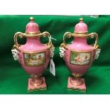 A pair of 19th Century pink ground porcelain lidded urns in the Vienna manner decorated with panels