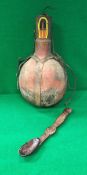 An African tribal carved wooden spoon and a leather mounted gourd shaped water vessel